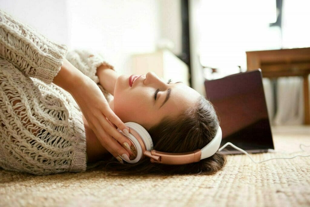 young woman sleeping with headphones ZL349WW e1630330316961 - Verbessere deine mentale Gesundheit mit Audiotools, Meditationen und Affirmationen